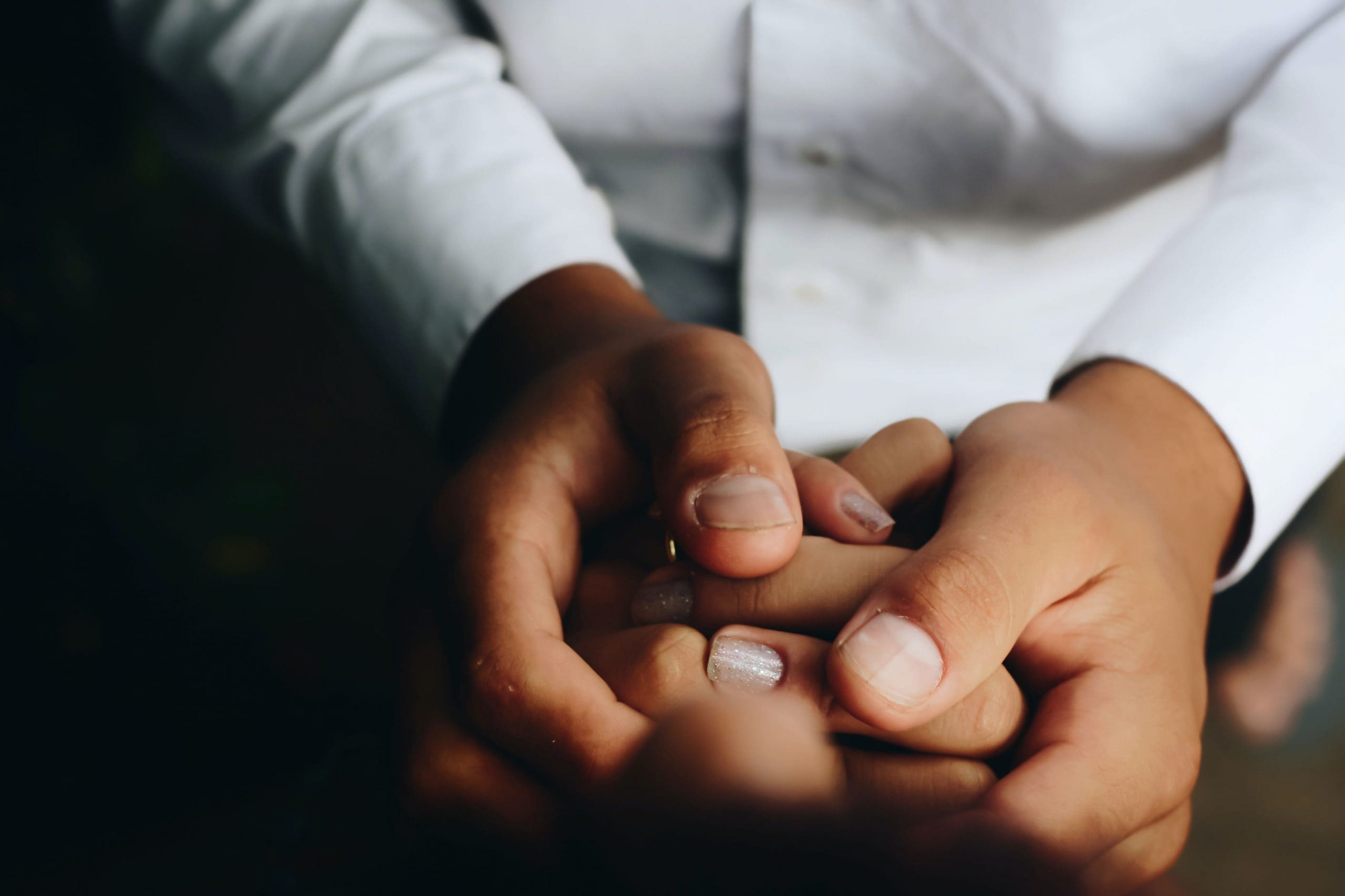 A close up of hands holding each other. A close up of hands holding each other.