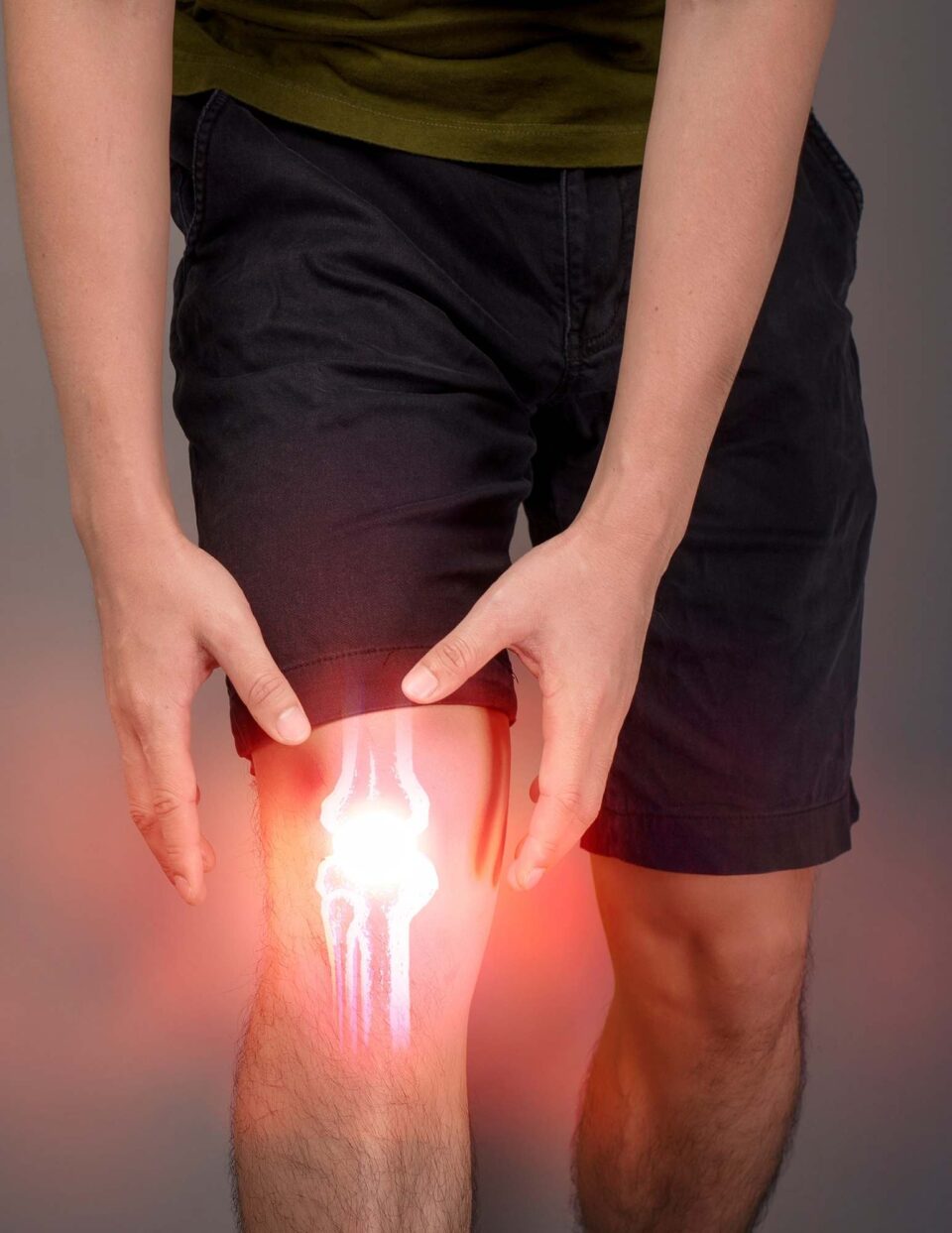 A man is holding his knee with a light on it.