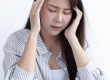 Asian woman with headache at the office stock photo.