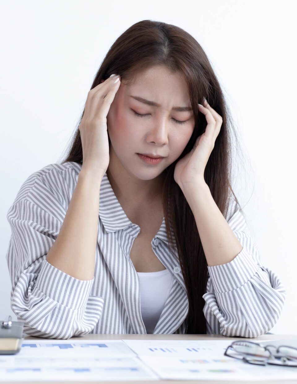Asian woman with headache at the office stock photo.