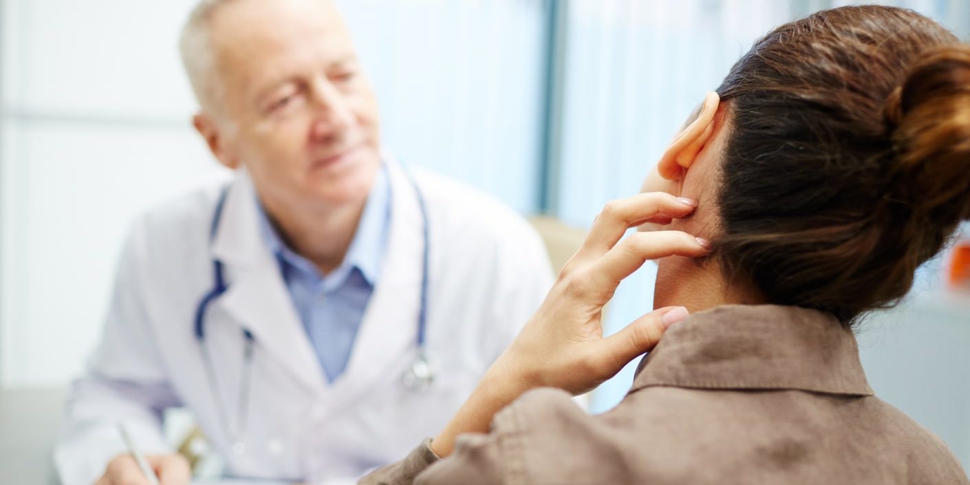 A woman is talking to a doctor about her ear.