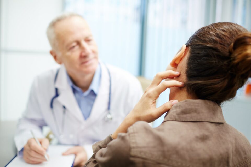 A woman is talking to a doctor about her ear.