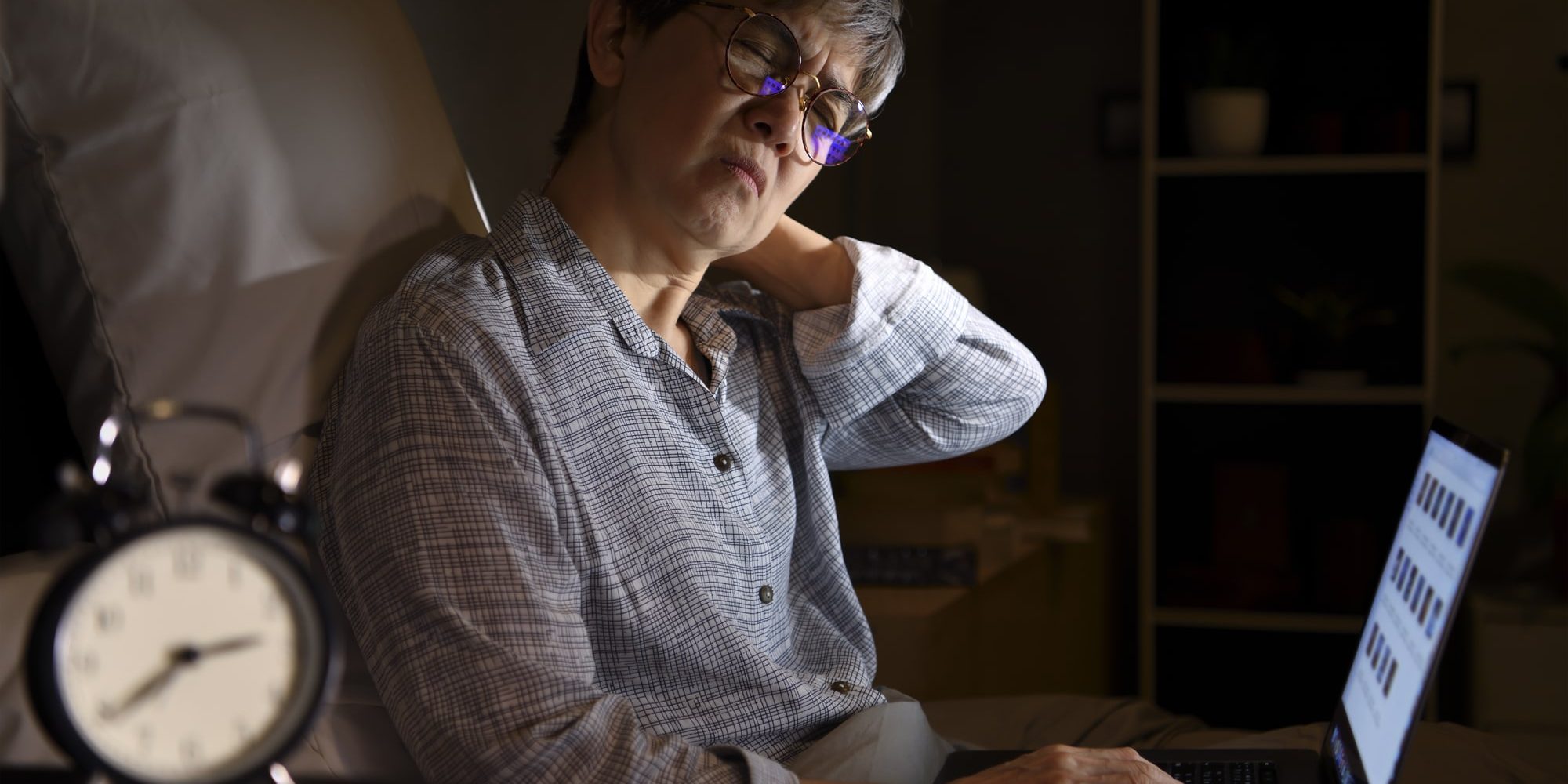 A woman sitting on a bed with a laptop. A woman sitting on a bed with a laptop.