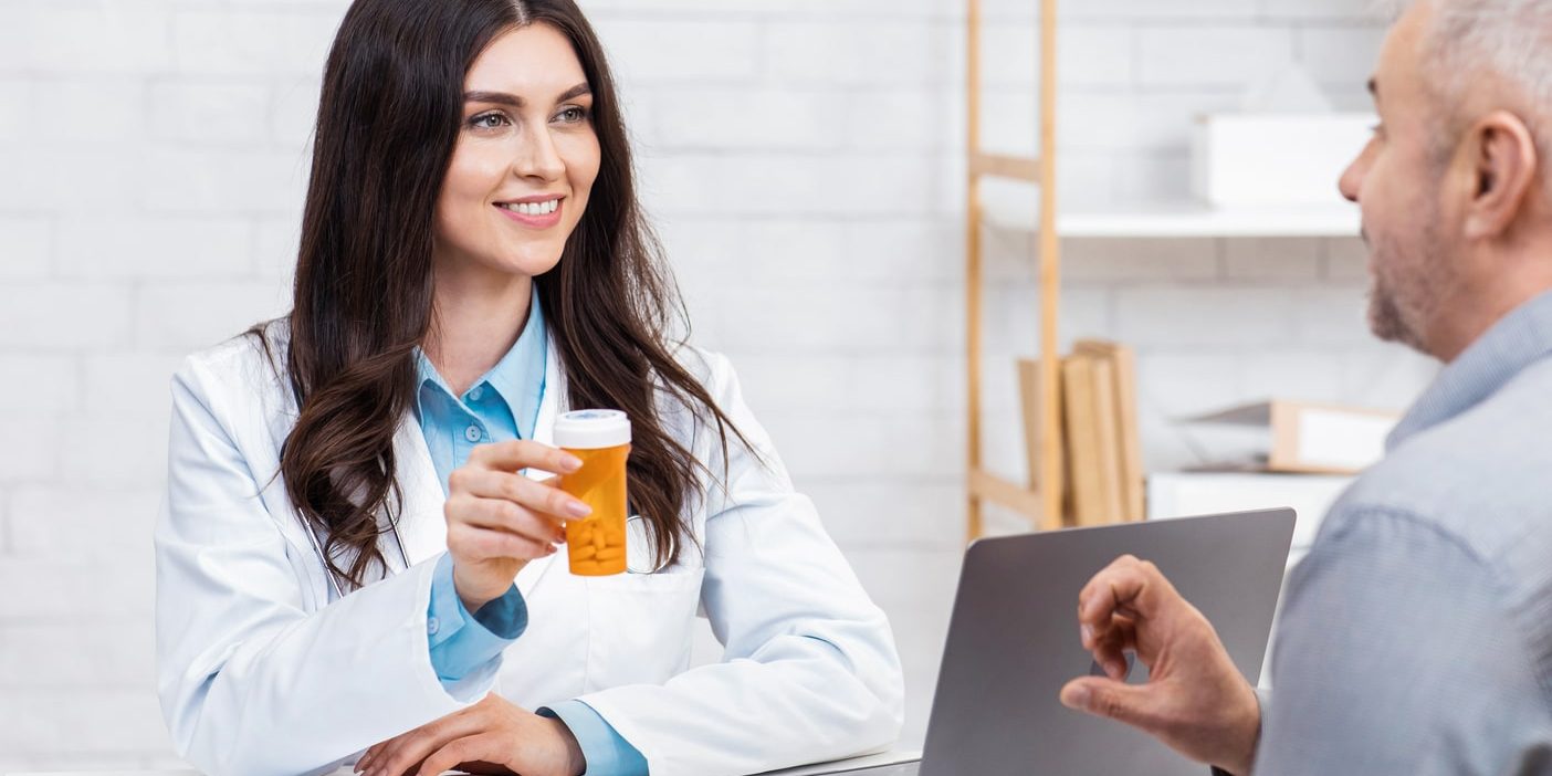 A doctor is talking to a patient in front of a laptop. A doctor is talking to a patient in front of a laptop.