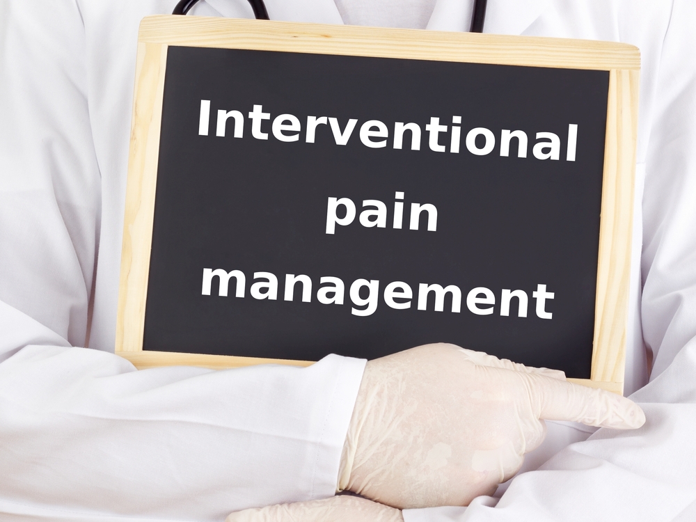Person in a white coat holds a sign that reads “Interventional pain management. Person in a white coat holds a sign that reads "Interventional pain management. Non-Surgical Pain Relief Port Charlotte