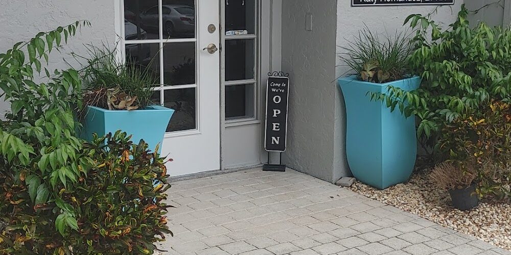 Entrance of the Family Spine and Pain Care Institute at suite 405 with a glass door, “Open” sign, and two large blue planters with greenery on either side. Entrance of the Family Spine and Pain Care Institute at suite 405 with a glass door, "Open" sign, and two large blue planters with greenery on either side. Office to have a procedure such as spinal cord stimulation in venice.