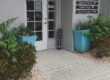 Entrance of the Family Spine and Pain Care Institute at suite 405 with a glass door, "Open" sign, and two large blue planters with greenery on either side. Office to have a procedure such as spinal cord stimulation in venice.