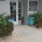 Entrance of the Family Spine and Pain Care Institute at suite 405 with a glass door, "Open" sign, and two large blue planters with greenery on either side. Office to have a procedure such as spinal cord stimulation in venice.